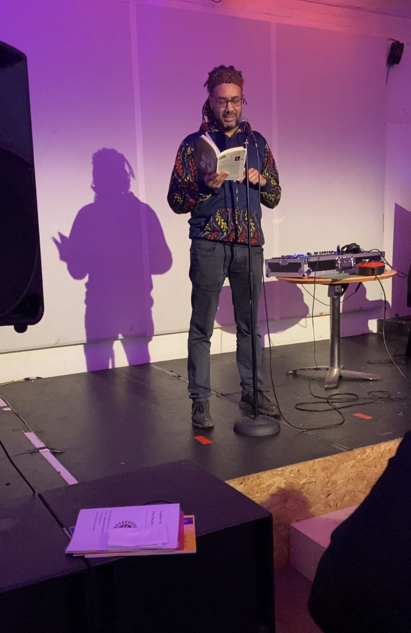 Spoken word performance on purple-lit stage